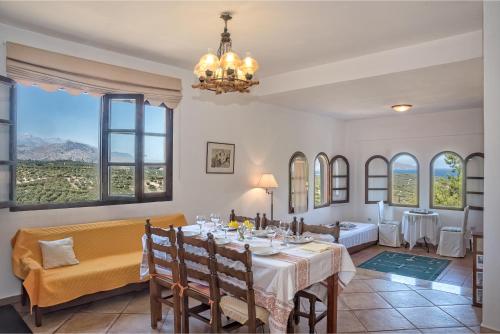 埃皮斯科皮·罗希姆诺Charming Country House with View的一间带桌椅和窗户的用餐室