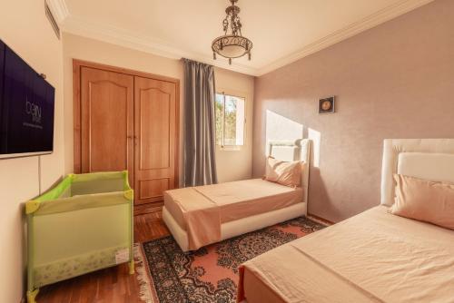 马拉喀什Majorelle family residence的一间酒店客房,设有两张床和电视
