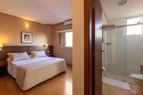 多拉杜斯巴哈马斯酒店的一间卧室配有一张床,浴室设有淋浴。