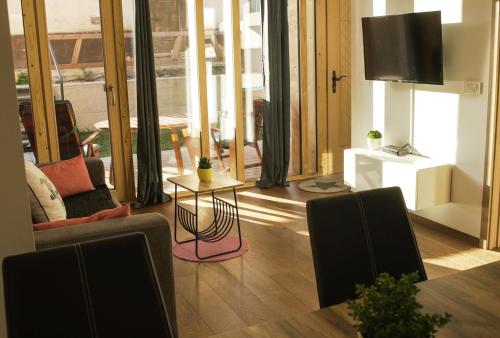 克拉尼斯卡戈拉Ski and Bike Apartment Rušovc的客厅配有电视和桌椅