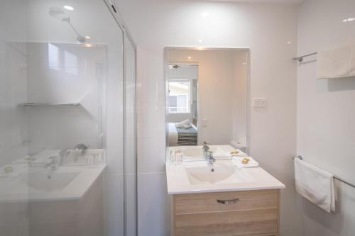 康约拉康约拉四大湖活力度假村的白色的浴室设有水槽和淋浴。