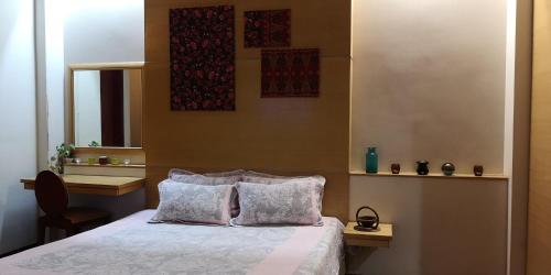史里肯邦安The Heritage Residence的一间卧室配有一张带两个枕头和镜子的床