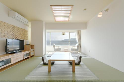箱根拉库恩酒店的客厅配有桌子和电视