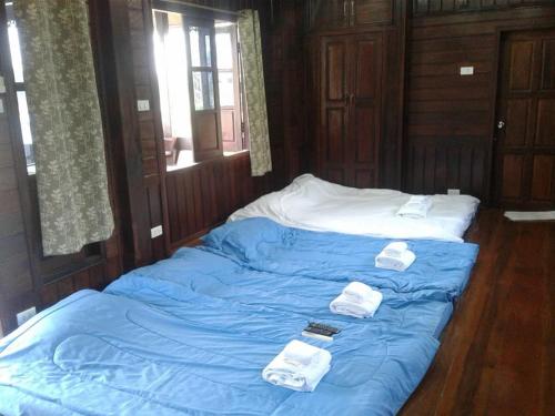 七岩บ้านฟ้ารักตะวัน的床上铺有蓝色床单和白色毛巾