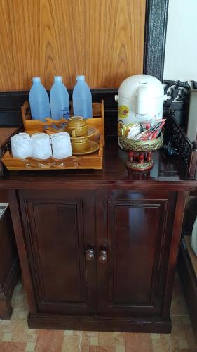 皮皮岛Paradise Pearl Bungalows的木柜,上面有盘子和蓝色花瓶