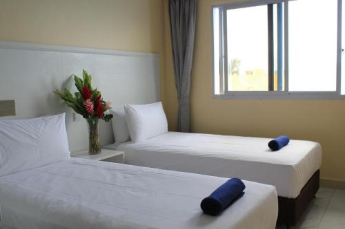 维拉港Central Bay Motel的酒店客房带两张床和花瓶