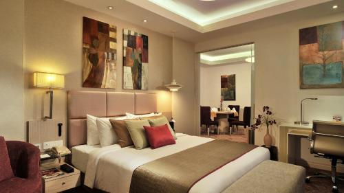 法里达巴德法里达巴德丽亭酒店的酒店客房设有一张大床和一张书桌。