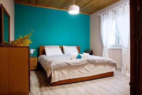 DorothéaSWEET HOME, LOUTRA POZAR的一间卧室配有一张蓝色墙壁的床