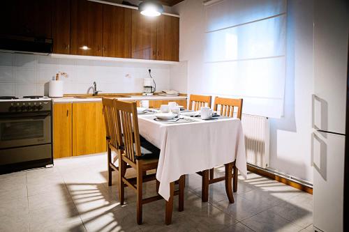 DorothéaSWEET HOME, LOUTRA POZAR的厨房配有一张桌子,上面有白色的桌布