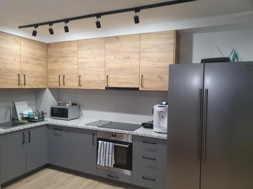 普沃茨克VILLA 17 Noclegi的厨房配有木制橱柜和不锈钢冰箱。