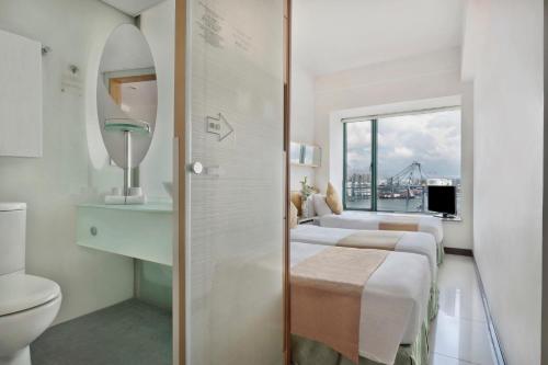 香港华逸酒店的一间带两张床、卫生间和窗户的浴室