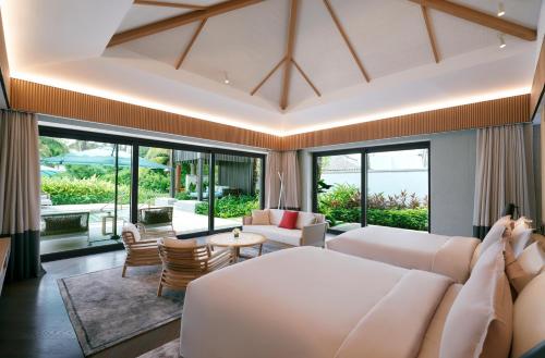 三亚海南土福湾嘉佩乐度假酒店的客厅配有白色的沙发和桌子