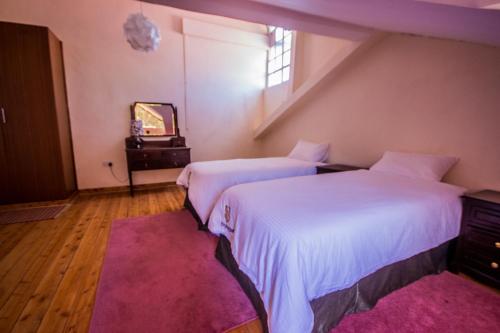 MjiniRiverfront Gardens的配有粉红色地毯的客房内的两张床