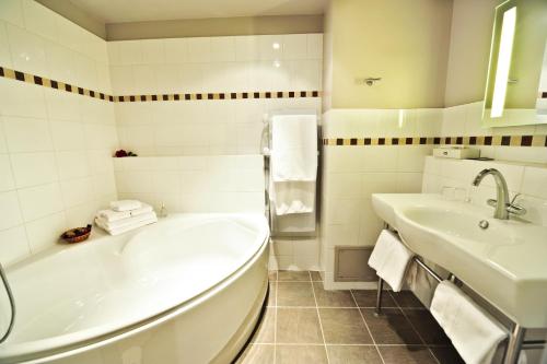 罗卡马杜尔艾斯克拉尔奇酒店的白色的浴室设有浴缸和水槽。