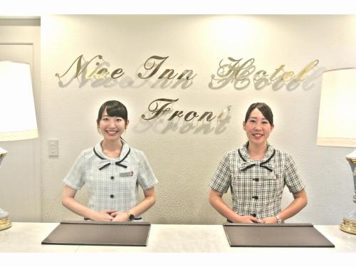 浦安尼斯市川东京湾酒店的两名妇女手提电脑站在桌子前