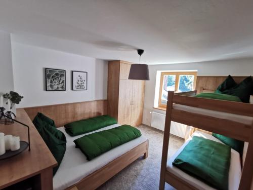 安纳贝格-伦格茨Ferienwohnung Hirscher的一间卧室配有两张双层床和绿色枕头