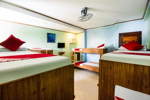 奥斯洛布Casa Bonita Inn Oslob的一间卧室配有两张床和一张双层床。