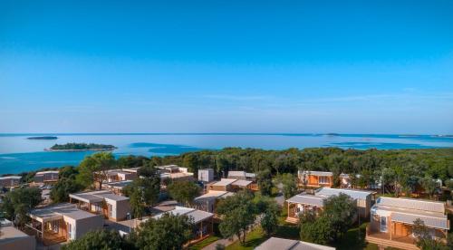 罗维尼Maistra Camping Veštar Mobile homes的享有城市的空中景致,设有房屋和海洋