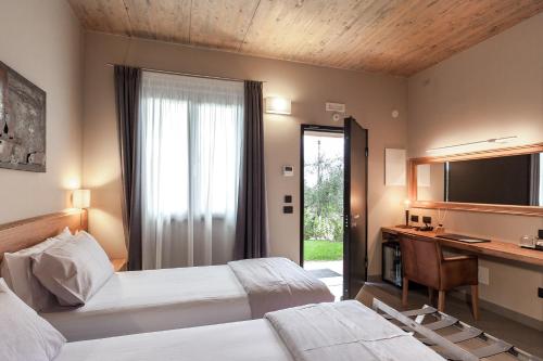 卡斯塔涅托卡尔杜奇Podere Vignanova Rooms & SPA的一间卧室配有两张床、一张桌子和一台电视。