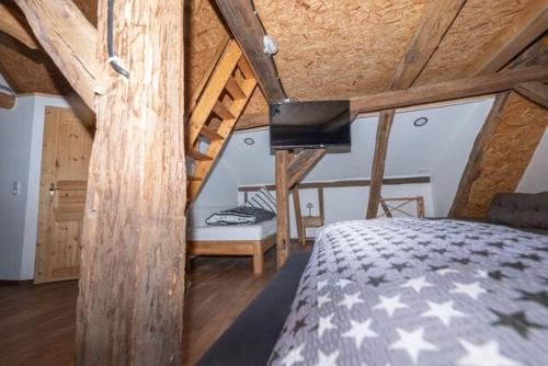 巴特索登-阿伦多夫Heuhotel und Gästehaus Kohlstädt的一间带一张床的卧室,位于带木制天花板的房间内