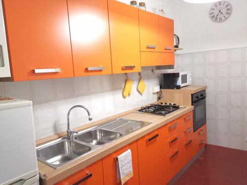 蓬特雷莫利Appartamento Liliana的厨房配有橙色橱柜和水槽