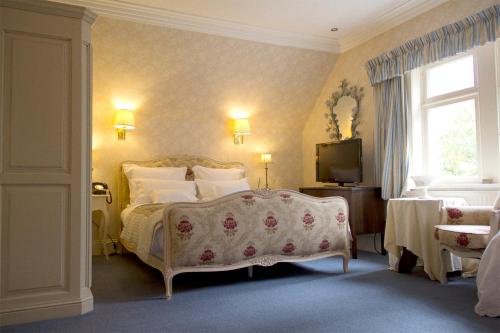 雷特芬莱考瑞格尔洛奇酒店的一间卧室配有一张床和一台电视