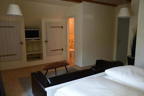 文西德尔Hotel Berggasthof Waldlust的一间卧室设有一张床,客厅设有电视。