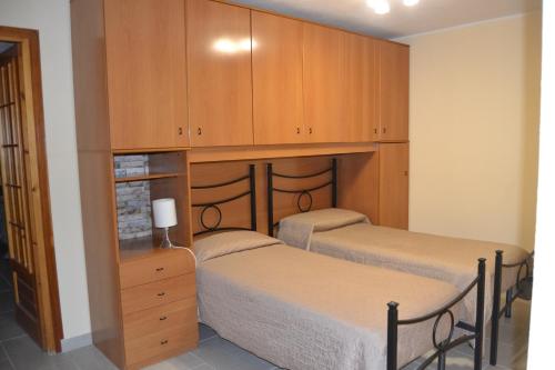 内比达CASA DEL MINATORE的配有木柜的客房内的两张床