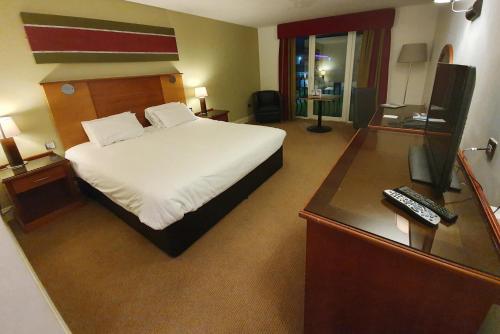 斯旺西塔楼温泉酒店的酒店客房配有一张床和一张带电脑的书桌