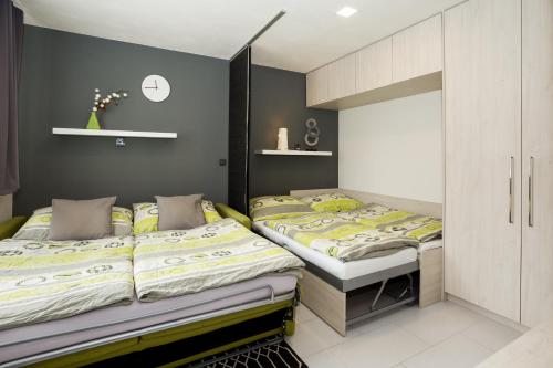 斯托泽克Apartmány Stožec - Stela Premium的卧室设有两张单人床和灰色的墙壁。
