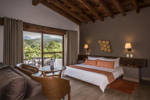 巴耶德布拉沃阿瓦达罗高尔夫及Spa度假酒店的一间卧室配有一张床、一张沙发和一个窗口