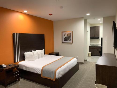 亨博尔Scottish Inn & Suites - IAH Airport的酒店客房带一张床和一个厨房