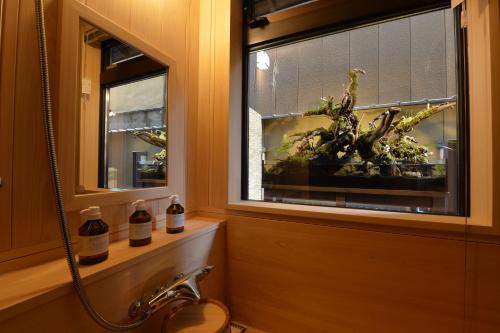京都Gion Oyado Kikutani的一间带水槽的浴室和一个带植物的窗户