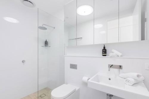 萨维特尔13 First Avenue Sawtell的白色的浴室设有卫生间和水槽。