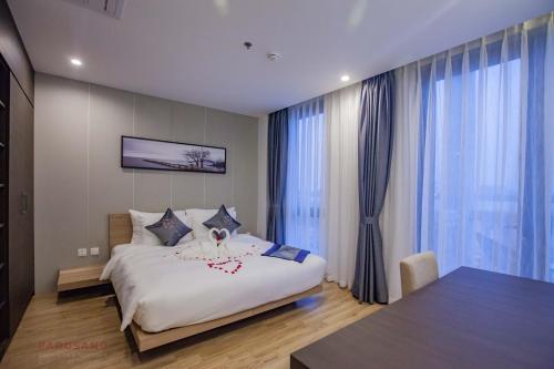 河内Parosand Hanoi Hotel的卧室设有一张白色大床和大窗户