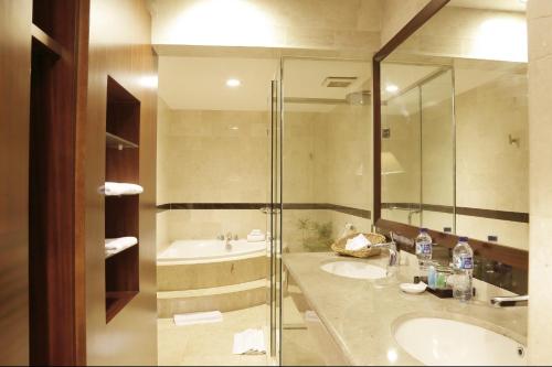 曼诺瓦里ASTON Niu Manokwari Hotel & Conference Center的一间带两个盥洗盆和淋浴的浴室