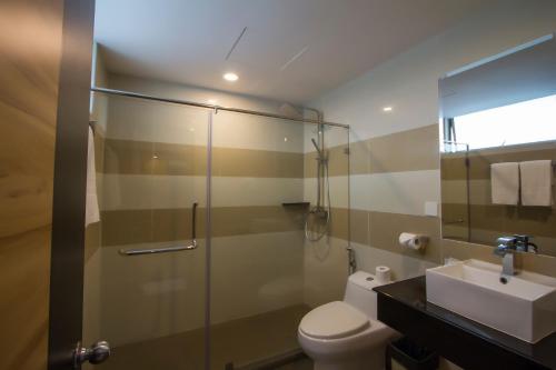 拉布安Mariner Hotel Labuan的带淋浴、卫生间和盥洗盆的浴室