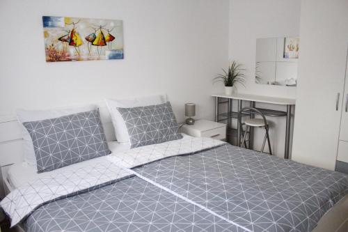 奥西耶克Apartman TIM的一间卧室配有一张带灰色和白色寝具的床