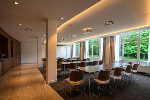 奈梅亨Sanadome Hotel & Spa Nijmegen的一间会议室,配有长桌子和椅子
