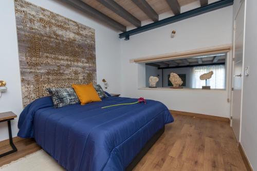 波加拉Domus Lapidis - El Estudio的一间卧室设有蓝色的床和砖墙