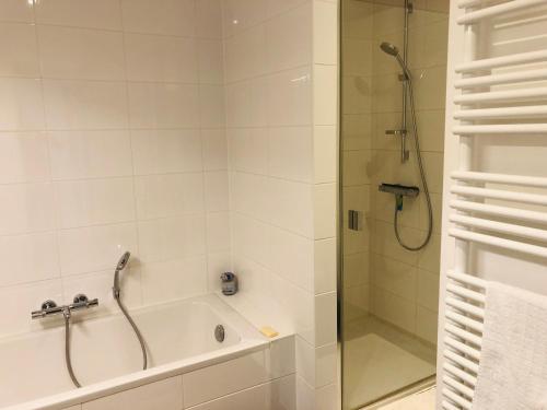 东代恩凯尔克EastDune的带淋浴和浴缸的浴室,配有玻璃门