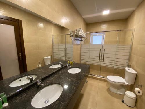 马达巴马赛克城市酒店的一间带两个盥洗盆和卫生间的浴室