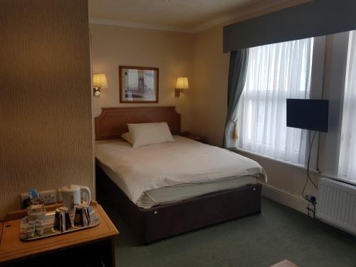 道格拉斯Welbeck Hotel & Apartments的酒店客房设有床和窗户。