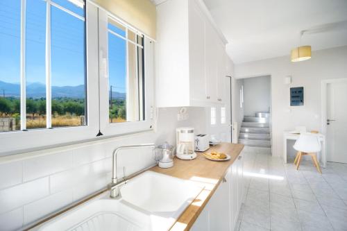 KhoumérionVilla Cacasa的白色的厨房设有水槽和窗户