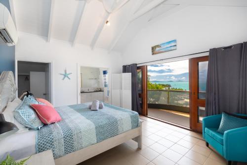 埃尔利海滩Absolute Airlie的一间卧室配有一张床和一张蓝色椅子