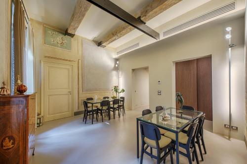 锡耶纳Residenza d'Epoca Le Aquile的一间设有玻璃桌和椅子的用餐室