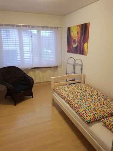 埃格尔金根Gästehaus Luma的一间卧室配有一张床和一把椅子