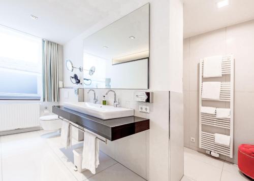奥斯纳布吕克罗曼蒂克瓦哈拉酒店的白色的浴室设有水槽和卫生间。
