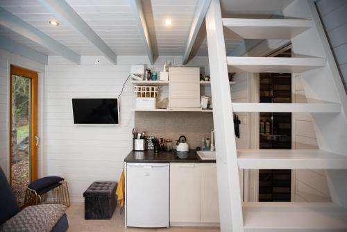 HiiessaareValhalla puhkemaja Hiiumaal的一个小房子里的厨房,有楼梯