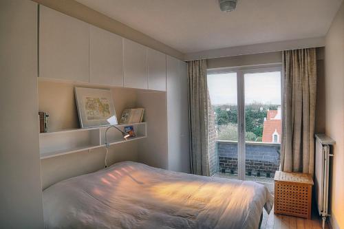 克诺克－海斯特祖特祖特酒店的一间卧室设有一张床和一个大窗户